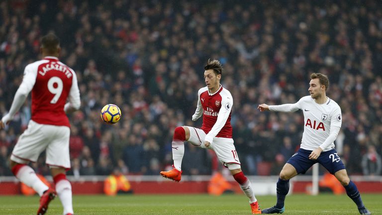 Arsenal's German midfielder Mesut Ozil (C) vies with Tottenham Hotspur's Danish midfielder Christian Eriksen (R) during the English Premier League football