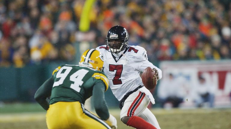 GREEN BAY, WI - JANUARY 4:  Michael Vick #7 of the Atlanta Falcons runs with the ball as he attempts to elude Kabeer Gbaja-Biamila #94 of the Green Bay Pac