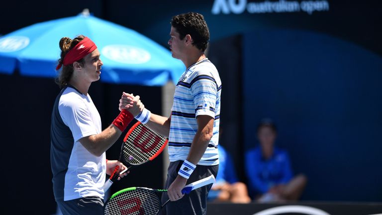 Slovakia's Lukas Lacko (L) shakes hands with Canada's Milos Raonic after winning their men's singles first round match on day two of the Australian Open te