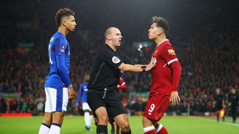 Referee Robert Madley intervenes as Mason Holgate of Everton and Roberto Firmino of Liverpool clash 