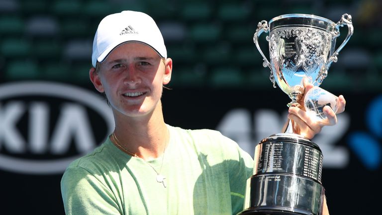 Sebastian Korda of the United States poses with the championship trophy after winning his Junior Boys' Singles Final