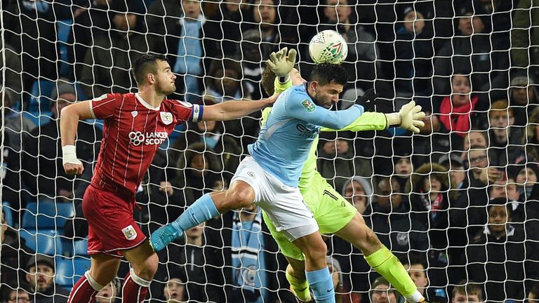 Manchester City's Argentinian striker Sergio Aguero (C) jumps to score their late winning goal during the English League Cup semi-final first leg football 