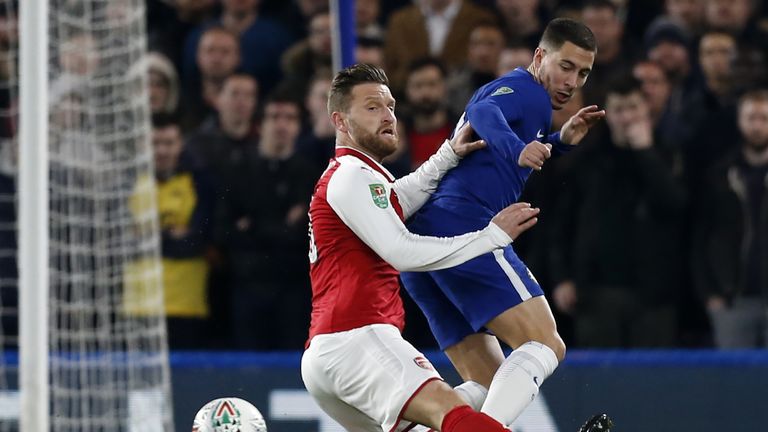 Arsenal's Shkodran Mustafi (L) vies with Chelsea's Eden Hazard during the Carabao Cup semi-final first leg