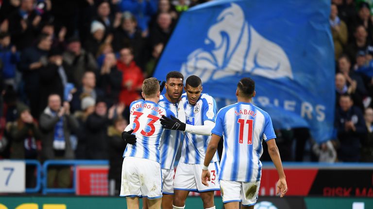 Steve Mounie is mobbed by his Huddersfield Town team-mates after scoring