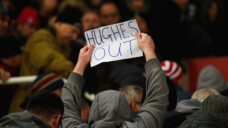 A fan holds a Hughes out sign during Stoke's defeat to Newcastle