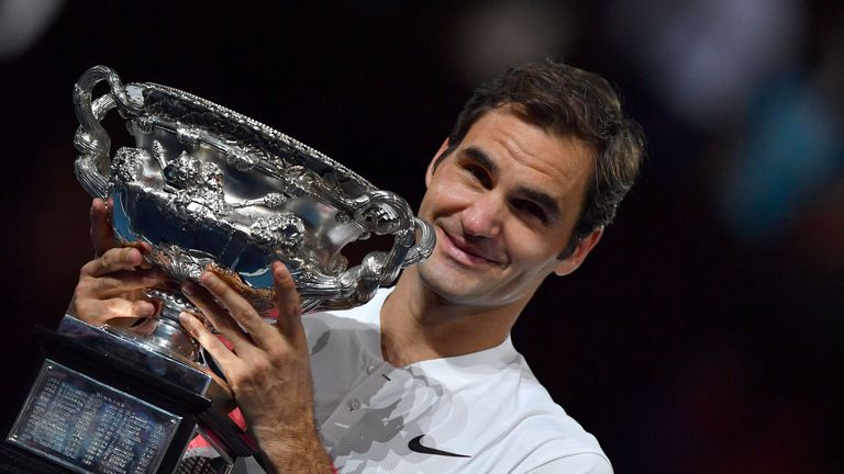 Switzerland's Roger Federer hold the trophy as he celebrates beating Croatia's Marin Cilic in their men's final at the Australian Open