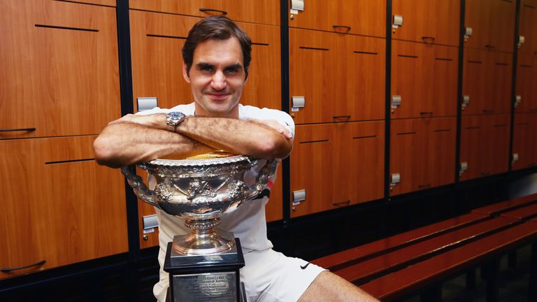 Roger Federer of Switzerland poses with the Norman Brookes Challenge Cup in the players locker room