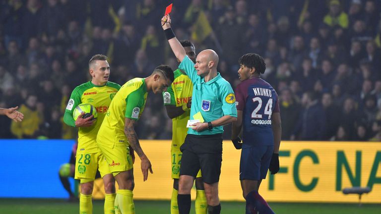 Nantes' Brazilian defender Diego Carlos (C) receives a red card from referee Tony Chapron