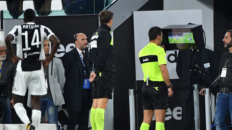 Referee Daniele Doveri (C) checks the VAR (video assistant referee) during the Italian Serie A football match Juventus vs Fiorentina on September 20, 2017 