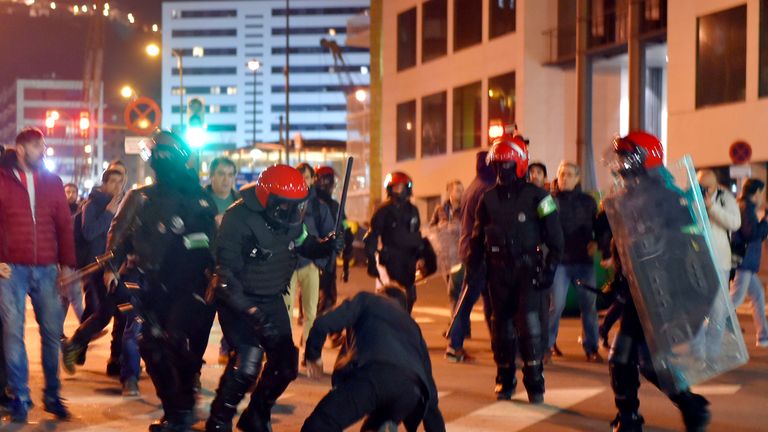 Basque autonomous police officers break up a group of Athletic Bilbao fans outside the San Mames stadium before the Europa League Round of 32 second leg fo