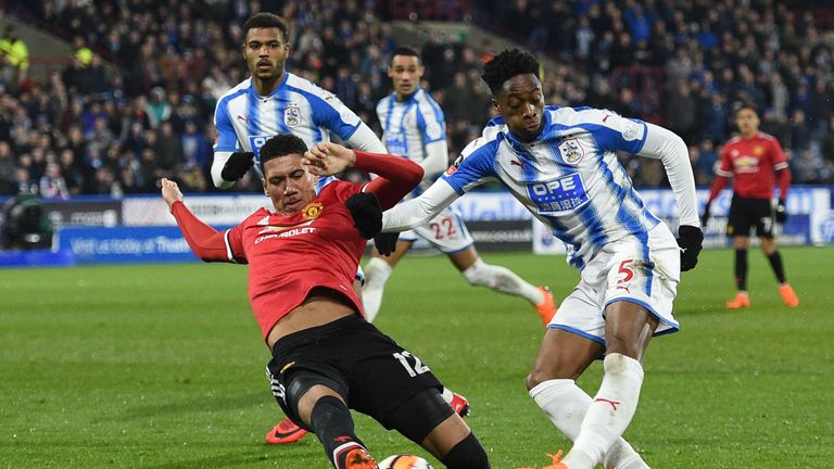 Manchester United's English defender Chris Smalling (L) blocks a shot from Huddersfield Town's Swiss-born Dutch defender Terence Kongolo during the English