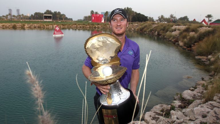 Chris Wood of England celebrates with the winner's trophy after the final round of the Qatar Masters Golf Tournament in the capital Doha, on January 26, 20