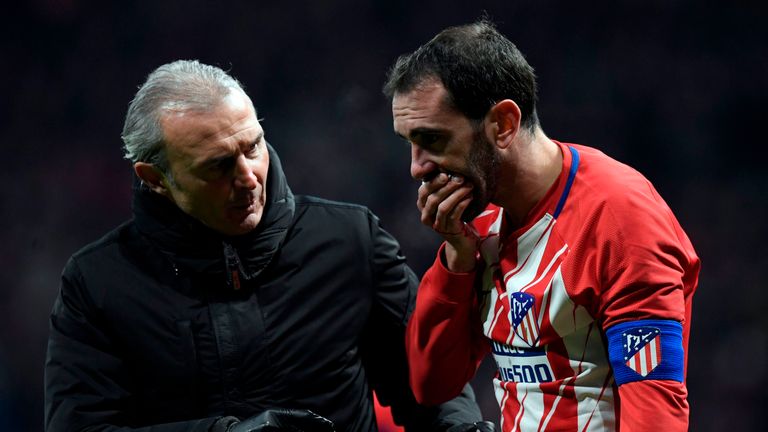 Atletico Madrid's Uruguayan defender Diego Godin (R) covers his mouth after resulting injured during the Spanish league football match between Club Atletic