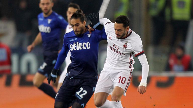 Hakan Calhanoglu competes for the ball with Martin Caceres