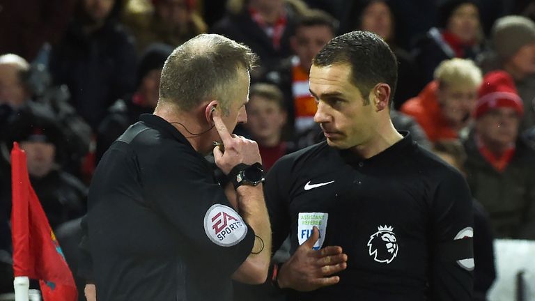 Referee Jonathan Moss (L) discusses the first penalty with his assistant during the Premier League match between Liverpool and Tottenham at Anfield
