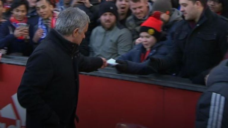 Jose Mourinho hands his notes to a young fan