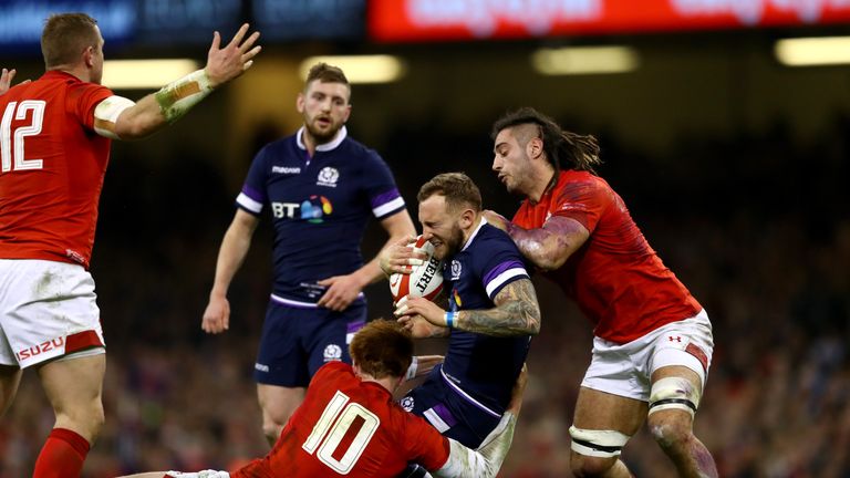 Byron McGuigan of Scotland is tackled by Josh Navidi of Wales and Rhys Patchell of Wales