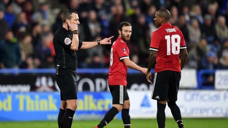 HUDDERSFIELD, ENGLAND - FEBRUARY 17:  Referee Kevin Friend consults with the Video Assistant Referee as Manchester United players await a decision over a J