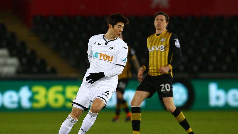 Swansea City's South Korean midfielder Ki Sung-Yueng (L) vies with Sheffield Wednesday's English striker Adam Reach during the English FA Cup 5th round rep