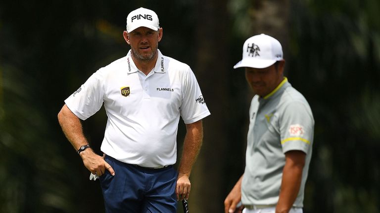 Lee Westwood (L) of England looks on as Hideto Tanihara (R) of Japan lines up his putt on the 9th hole during the second round of the 2018 Maybank Malaysia