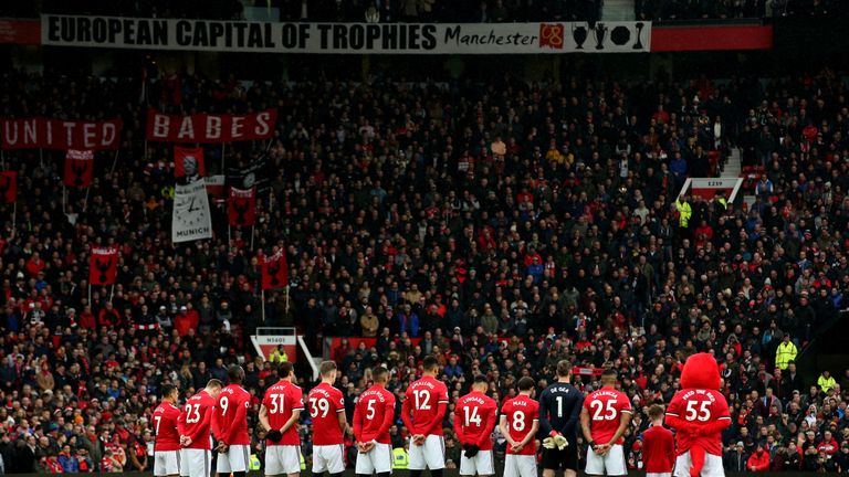 Fans, officials and players take part in a minute silence in tribute to the Manchester United players involved in the Munich air disaster