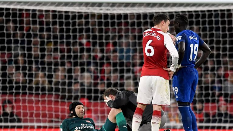 Arsenal goalkeeper Petr Cech (left) lies injured on the pitch during the Premier League match at the Emirates Stadium, London.