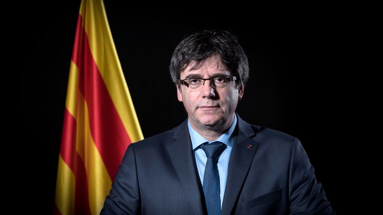 Exiled former Catalan leader Carles Puigdemont poses in front of a Catalan flag during a photo session in Brussels on February 7, 2018.  / AFP PHOTO / Emma