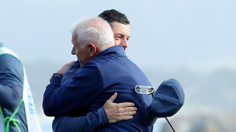 PEBBLE BEACH, CA - FEBRUARY 10:  Rory McIlroy of Northern Ireland and Gerry McIlroy embrace after finishing their round on the 18th green during Round Thre