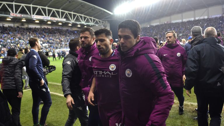 WIGAN, ENGLAND - FEBRUARY 19:  Sergio Aguero of Manchester City looks dejected as he leaves the pitch with assistant coach Mikel Arteta after the Emirates 