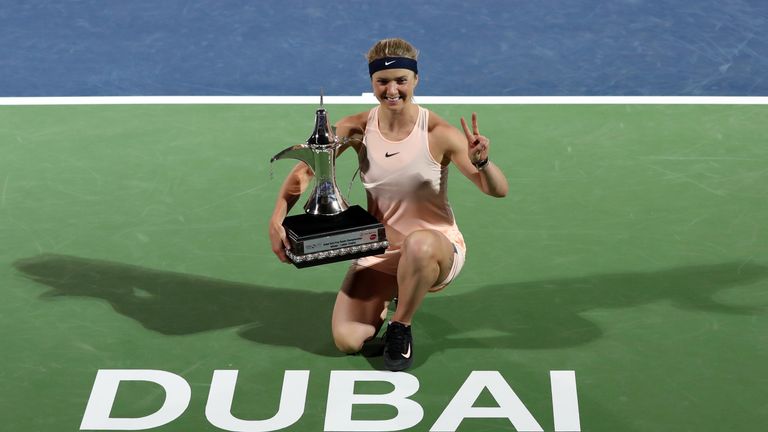Elina Svitolina of Ukraine poses while holding the champion's trophy after winning the WTA Dubai Duty Free Tennis Championship