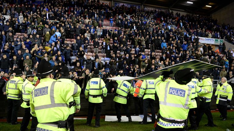  An advertising board is thrown at police as they attempt to prevent a pitch invasion after the Emirates FA Cup Fifth Round m