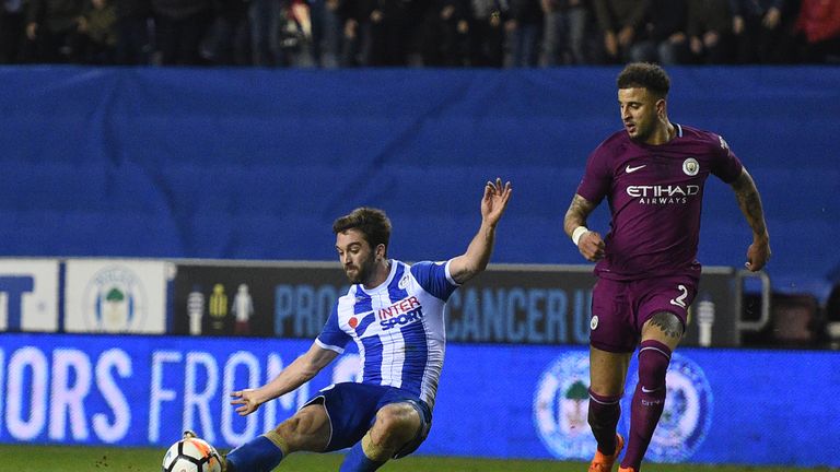 Wigan Athletic's English-born Northern Irish striker Will Grigg (L) scores his team's first goal during the English FA Cup fifth round football match betwe