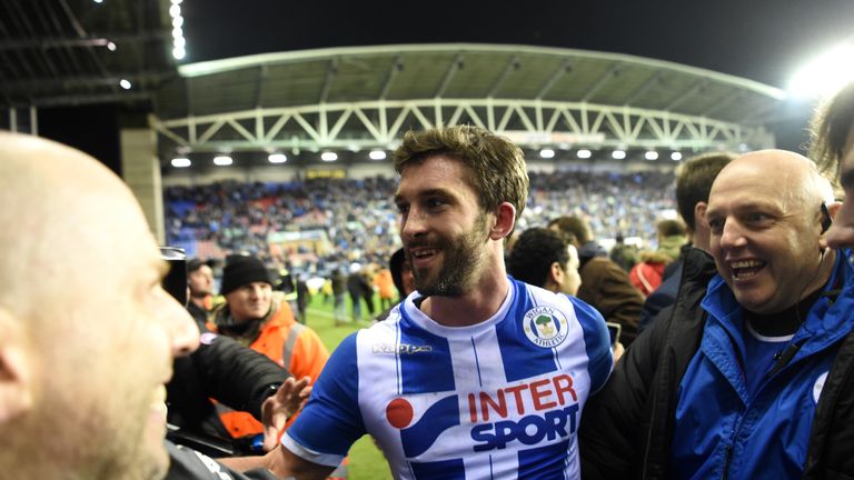 WIGAN, ENGLAND - FEBRUARY 19:  William Grigg of Wigan Athletic with fans on the pitch after the Emirates FA Cup Fifth Round match between Wigan Athletic an