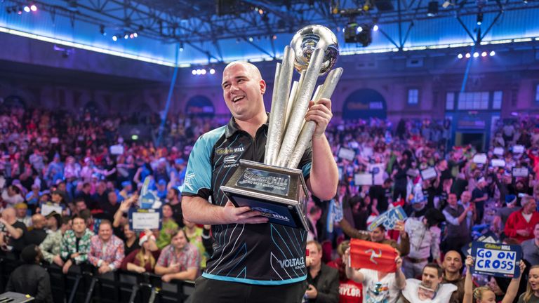 Rob Cross holds aloft the PDC World Darts Championship trophy after beating Phil Taylor