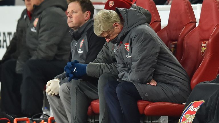 Arsene Wenger sits head bowed with his Arsenal side behind to Manchester City