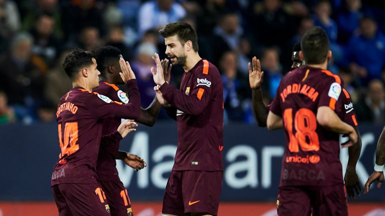 Philippe Coutinho and Gerard Pique celebrate in Barcelona's win over Malaga