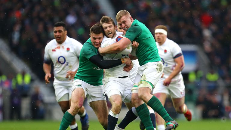 England's Elliot Daly (C) is tackled by Ireland's Dan Leavy (R) during the NatWest Six Nations match at Twickenham Stadium