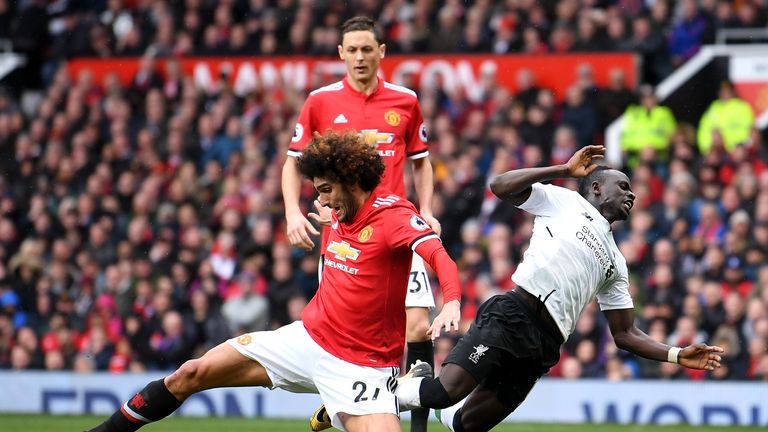 Sadio Mane and Marouane Fellaini in action during the match between Manchester United and Liverpool at Old Trafford on March 10, 2018