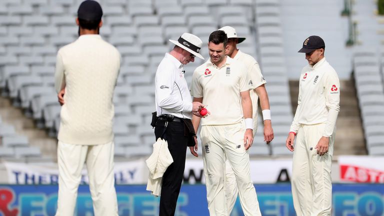 James Anderson of England (C) checks the state of the ball with the umpire during the second day of first Test cricket match between New Zealand and England at Eden Park in Auckland on March 23, 2018