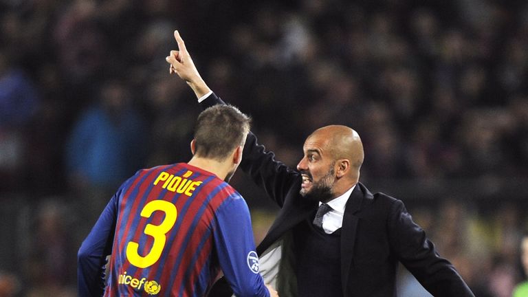 Pep Guardiola gives instructions while Gerard Pique looks onduring the Champions League quarter-final second leg football match FC Barcelona vs AC Milan on April 3, 2012