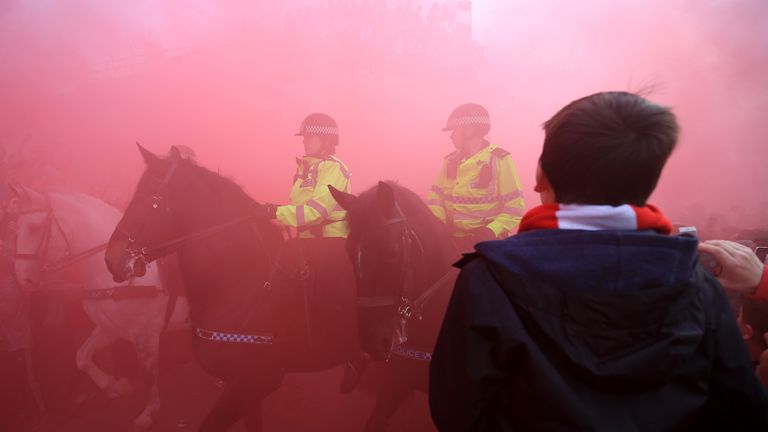 Mounted Police surrounded by Liverpool fans and in red smoke