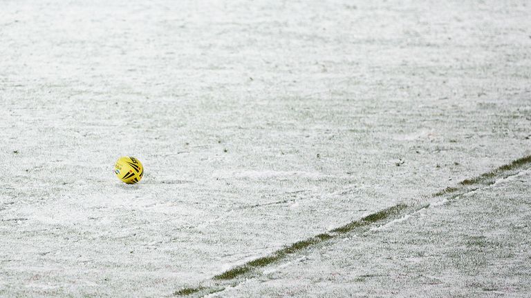 Rugby league  pitch covered in snow and a yellow rugby ball.