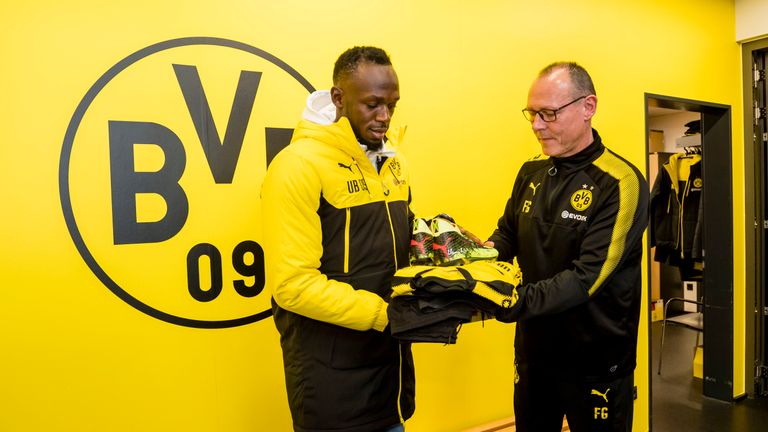 Usain Bolt receives his training gear from Borussia Dortmund kit manager Frank Graefen on March 22, 2018