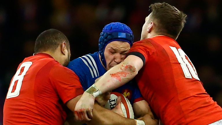 Taulupe Faletau (L) and Wales' fly-half Dan Biggar (R) tackle France's flanker Wenceslas Lauret 