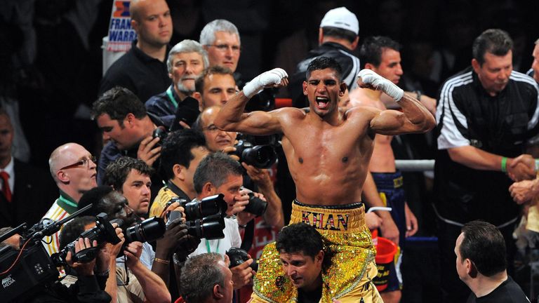 British boxer Amir Khan (C) celebrates after beating Ukrainian boxer Andreas Kotelnik during their WBA light-welterweight championship boxing match on July 18, 2009 at the M.E.N arena, in Manchester, north-west England. 