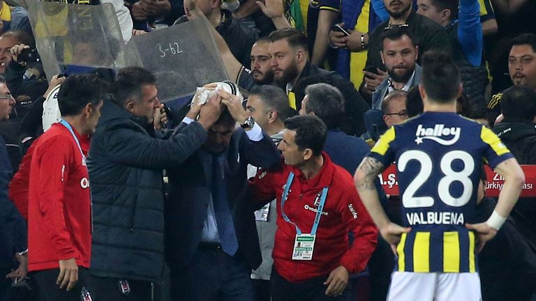 Besiktas head coach Senol Gunes holds his head after being hit by an object during the abandoned  Turkish Cup semi final 
