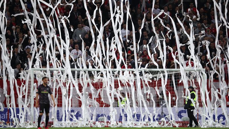 Stewards remove rolls of toilet paper thrown by fans at Opel Arena.