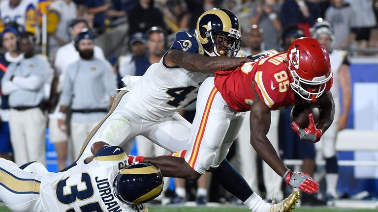 Frankie Hammond Jr. #85 of the Kansas City Chiefs is tackled in the fourth quarter by Marcus Roberson #47 and Mike Jordan #35 of the Los Angeles Rams