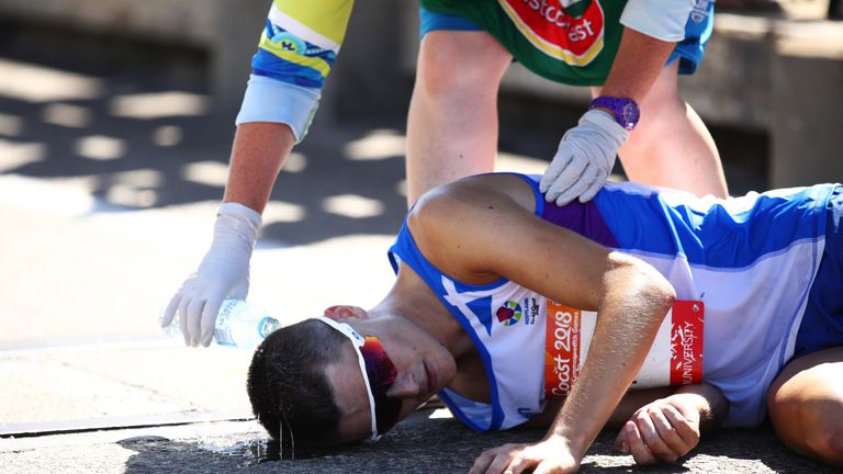 Callum Hawkins of Scotland is given assistance after collapsing in the Men's marathon