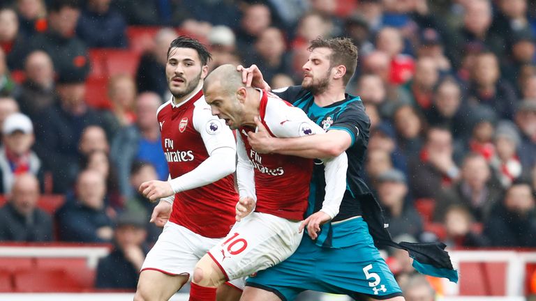 Jack Wilshere and Jack Stephens tussle during the Premier League match between Arsenal and Southampton at Emirates Stadium on April 8, 2018 in London, England.